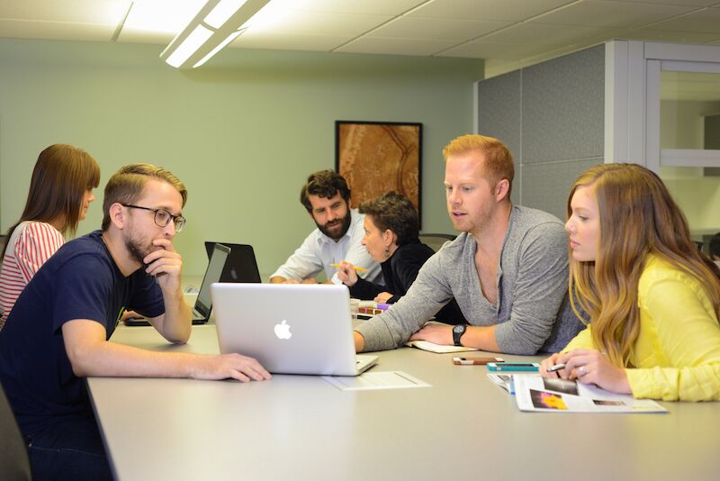 Young adults working at a meeting room table.